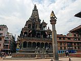 Kathmandu Patan Durbar Square 12 Krishna Mandir And Garuda Column Garuda kneels with folded arms on top of the column facing the Krishna Mandir in Patans Durbar Square. Krishna Mandir (1637) is an Indian style stone temple with a shikhara-style spire on top.